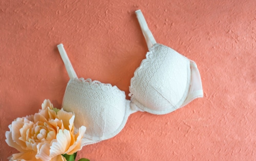 Beautiful white bra on the peach color bakground with a flower-img-blog