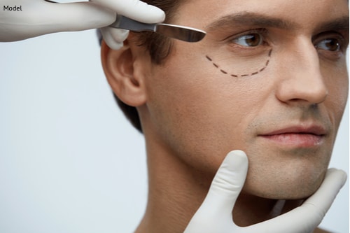 A man receiving a consultation for his eyelid lift that will help restore his youthfulness by removing facial sagging and wrinkles.