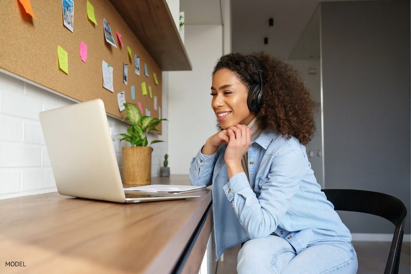 Woman using a video conferencing app to communicate from home.