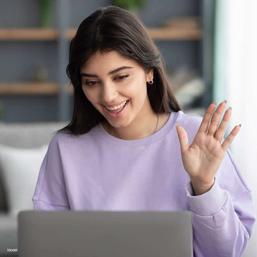 Woman waving in a video chat